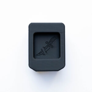 Close-up of a black rectangular plastic device with rounded corners on a white background.